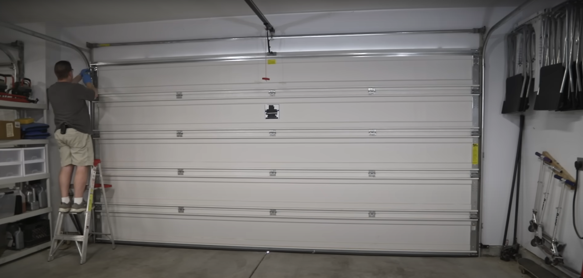 Alt text: Professional technician installing a modern garage door on a residential home.