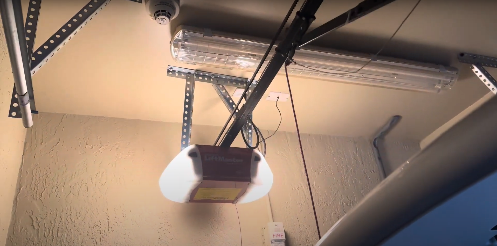 Alt text: A modern automatic garage door opener mounted on a residential garage ceiling.