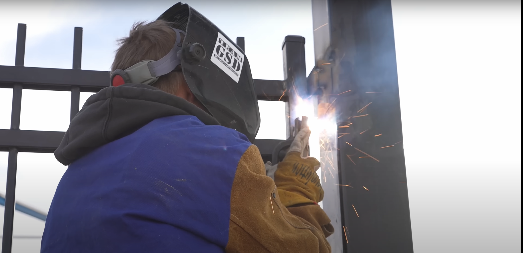 Alt text: A professional technician performing a gate repair on a residential driveway.